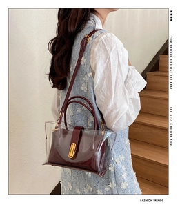 Detail of transparent PVC jelly bag with wine red inner pouch and golden metal oval lock