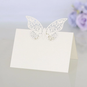 Detail of laser-cut butterfly place card on white pearlescent paper for weddings