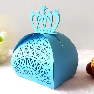 Detail of light blue laser-cut candy box with crown top and hollow floral patterns