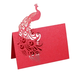 Macro detail of red laser-cut peacock place card with elegant pearlescent finish