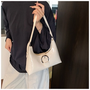 Detail view of cream-white glossy patent leather underarm bag with silver metal buckle