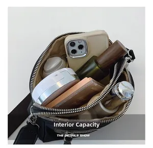 Capacité interne du sac à bandoulière noir avec trois compartiments zippés et doublure