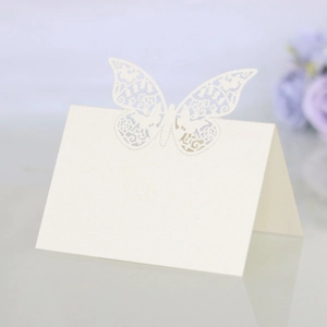 Macro detail of laser-cut butterfly place card in pearl white for wedding table decor