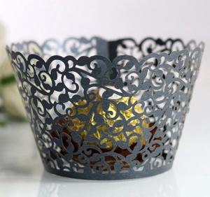 Laser-cut cupcake wrapper with intricate vine patterns in dark charcoal grey cardstock