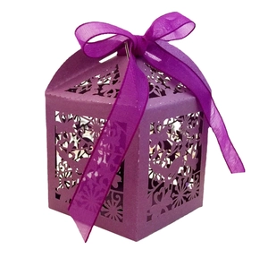 Detail of purple laser-cut candy box featuring floral patterns and a sheer ribbon bow