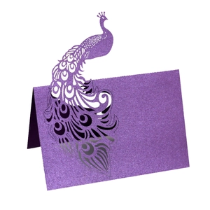 Detailed laser-cut peacock place card in purple glitter paper for wedding table decor