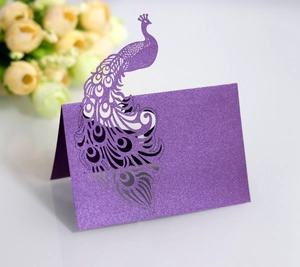 Close-up of laser-cut peacock place card in deep purple pearlescent paper