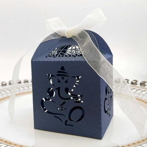 Detail of blue laser-cut Ganesha candy box with intricate patterns and white organza ribbon