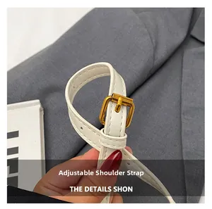 Detail of adjustable white leather strap with golden metal buckle for handbag