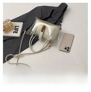 Detail of white leather inner pouch and transparent outer bag with golden lock closure