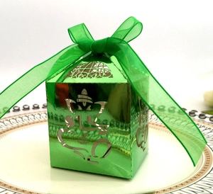 Elegant green metallic gift box with elephant cutout and organza ribbon bow on white plate