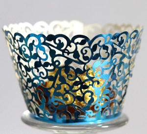Blue laser-cut cupcake wrapper with floral vine pattern and metallic finish texture