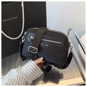 Détail de la bandoulière noire en nylon avec rivets argentés et sangle large tissée