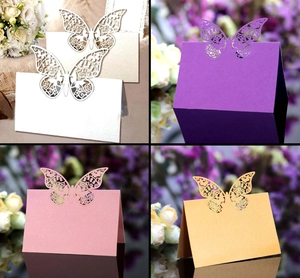 Detailed laser-cut butterfly place cards in pearlescent white, purple, pink, and gold colors