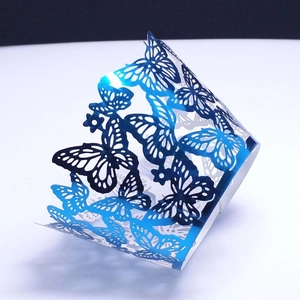 Macro view of metallic navy blue laser-cut butterfly cupcake wrappers for wedding decor