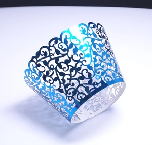 Detail of laser-cut blue metallic cupcake wrapper with elegant vine hollow patterns