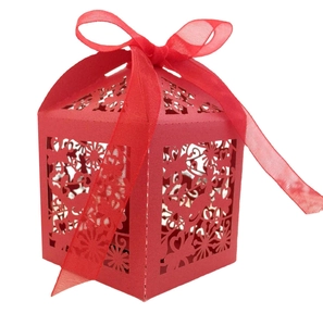 Detail of laser-cut floral patterns and red ribbon bow on the wedding favor box