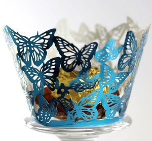 Detailed laser-cut butterfly cupcake wrappers in metallic blue for elegant party decor