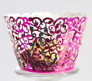 Macro shot of rose red laser-cut cupcake wrapper with vine patterns and metallic finish