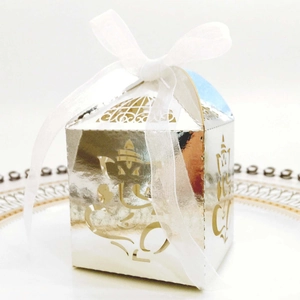 Detailed silver laser-cut candy box featuring Ganesha design and a white organza ribbon
