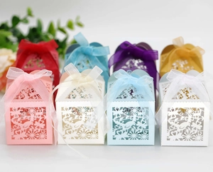 Detailed laser-cut candy boxes with bird and floral patterns and soft ribbon bows