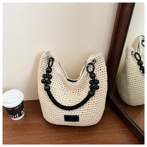 Detail of crochet weave bag with black wax rope handles and elegant wood bead accents