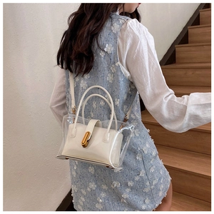 Detail of transparent PVC jelly bag featuring a white inner pouch and golden metal buckle