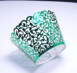 Detail of green metallic laser-cut vine lace wrappers for cupcakes and party favors