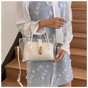 Sac jelly transparent avec pochette intérieure blanche et fermoir doré porté par un modèle