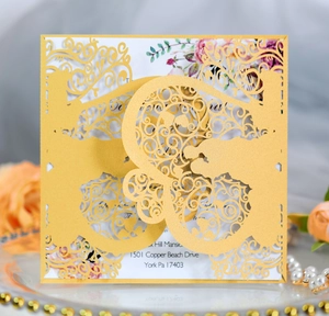 Elegant gold laser cut wedding invitation card with intricate hollow vine patterns