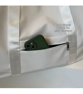 Close-up of the back zipper pocket on a white tote bag for secure phone storage