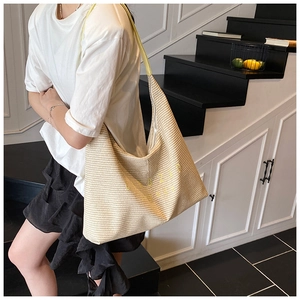 Detail view of woven straw tote bag featuring yellow straps and GEZAD letter embroidery