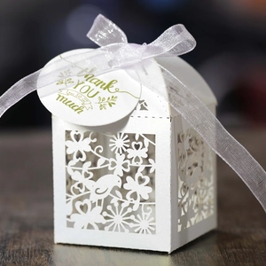 Detail of laser-cut wedding favor box with bird patterns and Thank You tag
