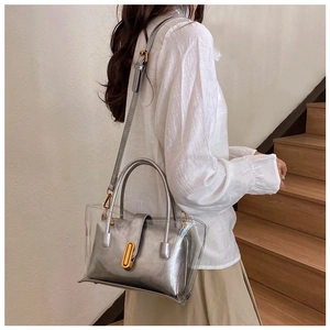 Modèle portant un sac en PVC transparent avec pochette argentée et fermoir doré élégant