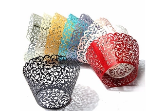 Macro shot of assorted laser-cut cupcake wrappers with intricate hollow vine patterns