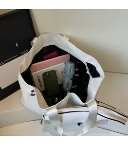 Detail view of large white PU tote bag interior showing spacious storage for a tablet