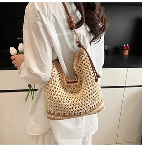 Detail of hollow woven tote bag featuring wooden beads and premium leather shoulder strap
