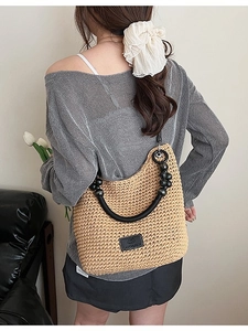 Chic woven shoulder bag in beige with black bead strap and leather patch detail