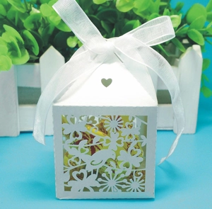 Detail showing laser-cut bird and flower patterns on white wedding favor gift box