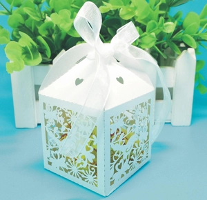 Close-up of laser-cut birds and floral patterns on white wedding candy gift box