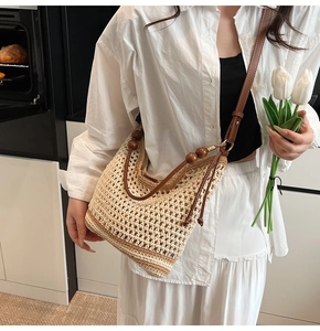 Detail of beige crochet tote bag with wooden bead straps and brown stripe bottom