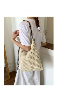 Detail der beige Häkeltasche mit dekorativen Holzperlen und dunklen Seilschultergurten