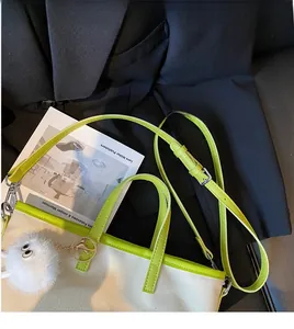 Detail of canvas tote bag with vibrant green leather trim and cute faux fur eye charm