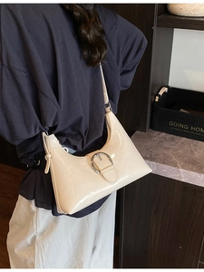 Chic beige patent leather hobo shoulder bag with a stylish silver metal buckle design