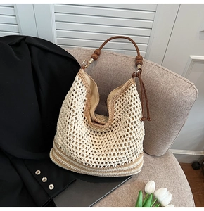 Detail of hollow crochet tote bag with brown leather handle and wooden bead accents