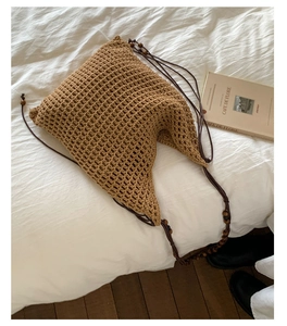 Detail der braunen Häkeltasche mit dekorativen Holzperlen und offenem Maschendesign