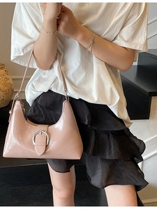 Pink patent leather underarm bag with large silver buckle and vintage shoulder strap design