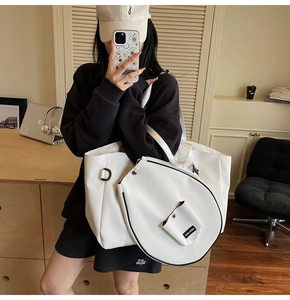 Detail of white leather tote featuring a tennis racket shaped pocket and small coin purse