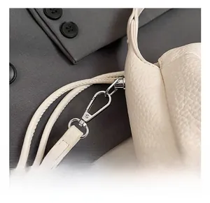 Detailed macro view of white litchi grain leather bag with premium silver lobster clasp