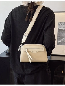 Sac bandoulière minimaliste beige avec large bandoulière et détails de glands